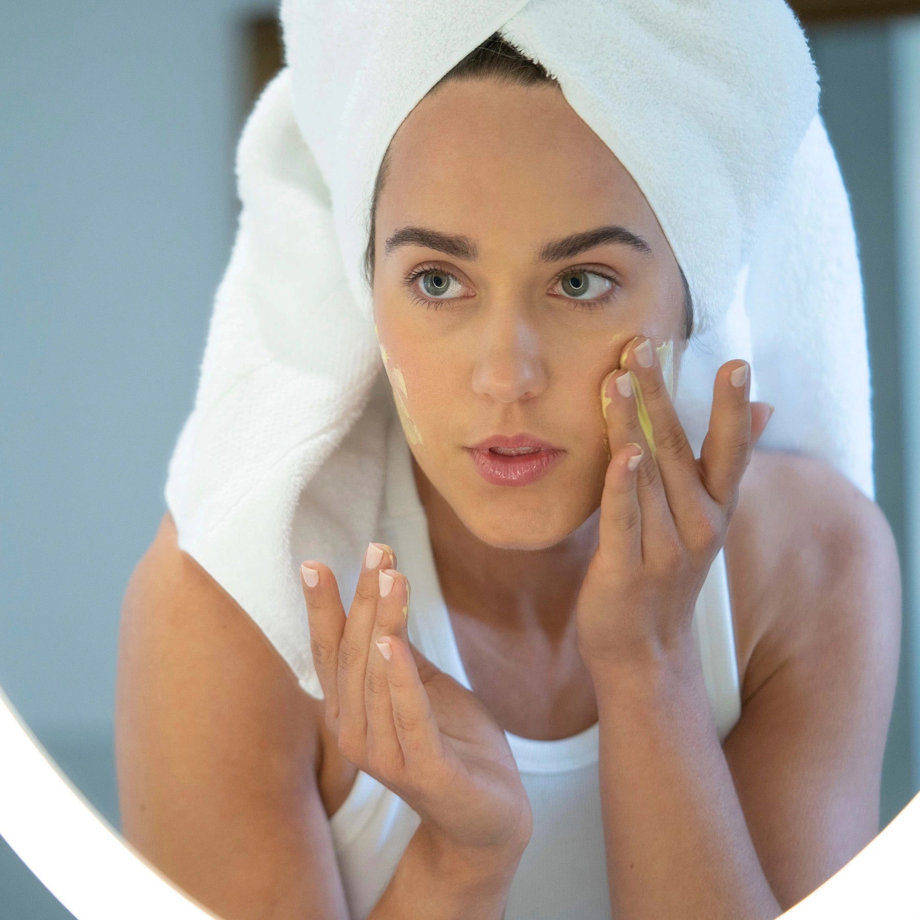 Woman applying VegOut Organics natural skincare cream in her morning routine. Hydrating and nourishing formula for a radiant, healthy complexion. Clean, vegan, and plant-based skincare.