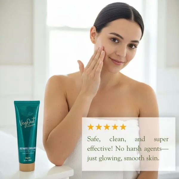 A woman in a white towel gently applies Veg Out Organics Enzymatic Exfoliator to her cheek while smiling. A visible 5-star user review highlights the product as safe, clean, and super effective with no harsh agents—just glowing, smooth skin.