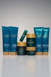 A complete set of VegOut Organics facial skincare products including Glow Bright Cleanser, Enzymatic Exfoliator, Essential Mask, Eye Renewal Complex, Skin Perfect Moisturizer, and Lip Balm, beautifully arranged against a neutral background. This Facial Deluxe Bundle offers a plant-based, non-toxic skincare routine enriched with Aloe Vera, Papaya Enzymes, and Hemp Extract for glowing, healthy skin.