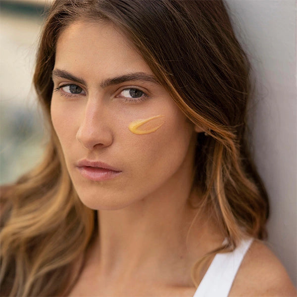 Model wearing vegan facial serum on cheek—Vitamin C+ Serum from Veg Out Organics for radiant, healthy-looking skin.